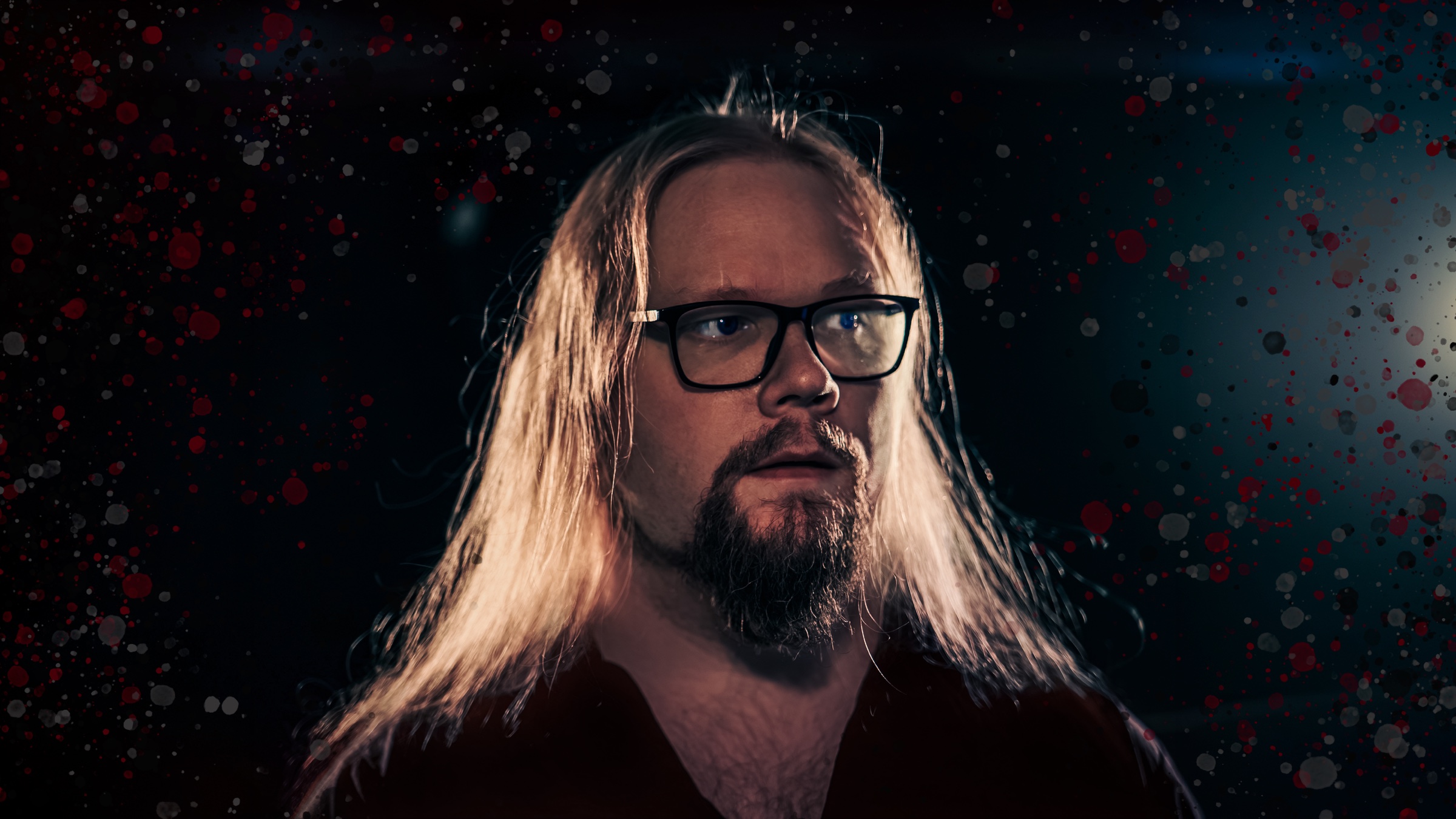 Kalle Caiania tummassa, punaisin ja vaalein roiskein sävytetyssä artistikuvassa